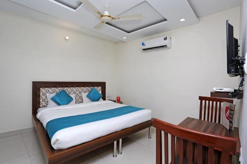 Schlafzimmer mit einem Bett mit blauen Kissen und einer Decke in der Unterkunft Hotel Sea in Patiala