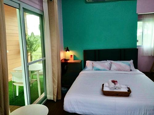 a bedroom with a bed with a tray with a towel on it at Ban Ing Suan in Samutprakarn