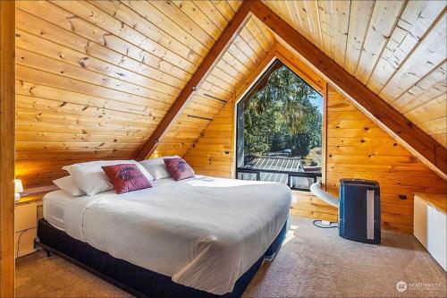 a bedroom with a bed in a wooden cabin at NEW: Steps from White River near Mount Rainier National Park in Greenwater