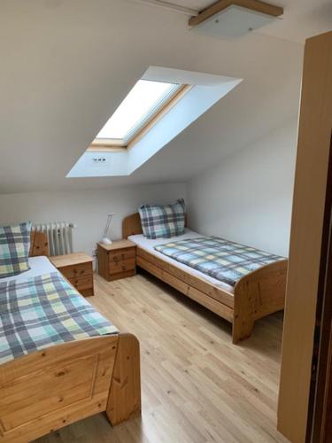 a attic room with two beds and a skylight at Naturkost-Hotel Harz in Bad Grund