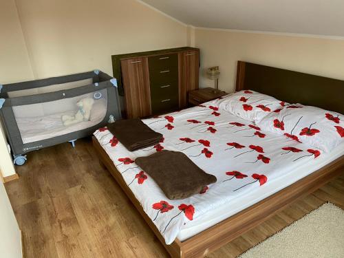a bedroom with a bed with red flowers on it at Apartament Polański z tarasem na dachu in Rabka