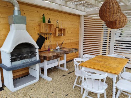 a kitchen with a stove and a table and chairs at Vidéki Varázs Vendégház in Bogács