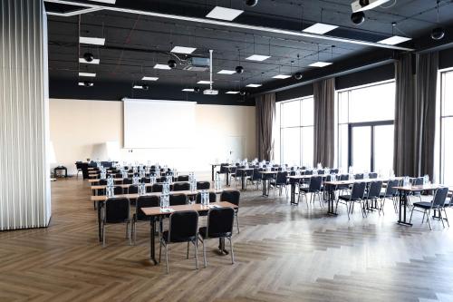 a large room with tables and chairs and a projection screen at Citi Hotel's Warszawa-Falenty in Raszyn