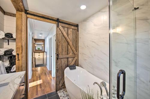 a bathroom with a tub and a glass shower at Marietta Home with Private Hot Tub, Pool Table! in Marietta