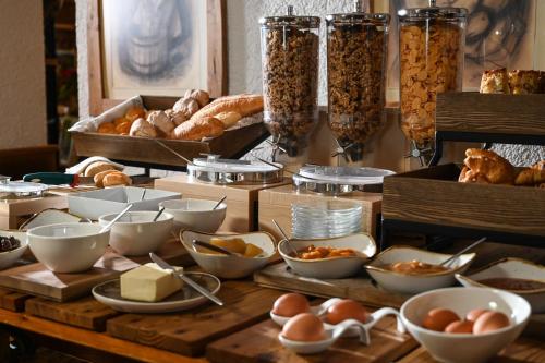 a table topped with lots of bowls of food and bread at Rifugio Cereda in Fiera di Primiero