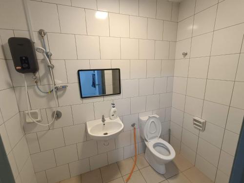 a bathroom with a toilet and a sink and a mirror at Elvy Homestay Alam Sutera Puncak Alam in Bandar Puncak Alam