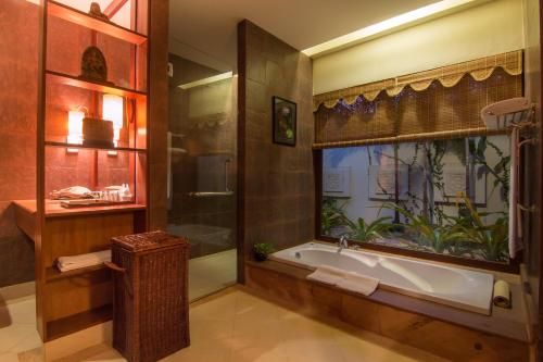 a bathroom with a bath tub and a window at Palace Residence & Villa Siem Reap in Siem Reap