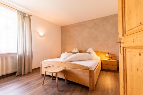 1 dormitorio con cama de madera y ventana en Apartment Christian, en Nova Levante