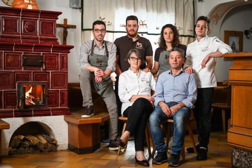 a group of people posing for a picture in front of a fireplace at Rifugio Cereda in Fiera di Primiero