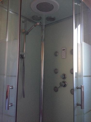 une douche dans une salle de bain avec une porte vitrée dans l'établissement Gite au coeur de la Provence & SPA, à Saint-Cannat