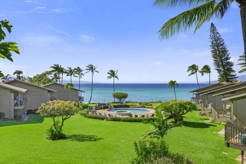 a yard with a pool and the ocean in the background at Oceanside-Spectacular View and Poolside Oasis in Kahana