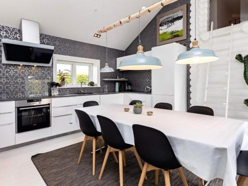 a kitchen with a white table and black chairs at 6 person holiday home in Otterup in Otterup