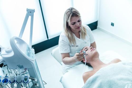 a woman in a hospital room brushing a patients teeth at Ilirija Resort Hotel Ilirija in Biograd na Moru