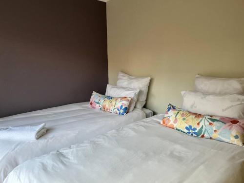 two beds with pillows sitting next to each other at The Reeds: 2 Bedroom townhouse in Centurion