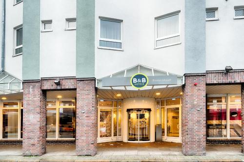 una fachada de un edificio con una tienda de aaq en B&B Hotel Bremen-Altstadt en Bremen