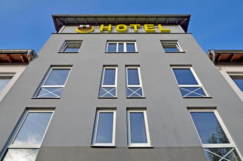 een groot grijs gebouw met een hotelbord bovenop bij B&B Hotel Düsseldorf-Ratingen in Ratingen