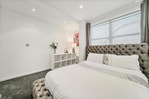 Modern1Bed Apartment London Camberwell Denmark Champion Hill في لندن: غرفة نوم بيضاء مع سرير كبير ونافذة