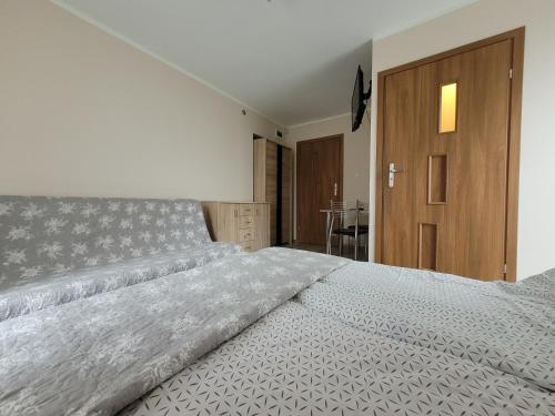 una camera con un grande letto e una porta in legno di Przy Deptaku a Mielno