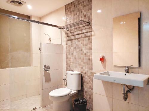 y baño con aseo, lavabo y ducha. en Shinta Guesthouse en Malang