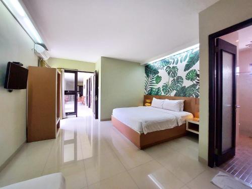 a bedroom with a bed and a television in it at Shinta Guesthouse in Malang