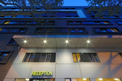 un edificio con un signo de repetición delante de él en B&B Hotel Frankfurt City-Ost, en Frankfurt