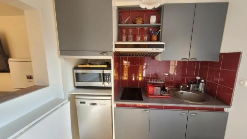 une petite cuisine avec un évier et un micro-ondes dans l'établissement Villa Collioure Mar i Munt, à Collioure