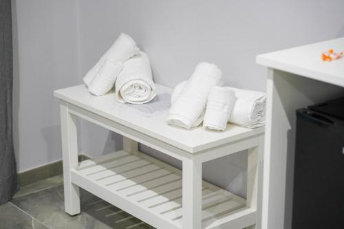 Una mesa blanca con toallas enrolladas. en Piedigrotta b&b Luxury, en Pizzo