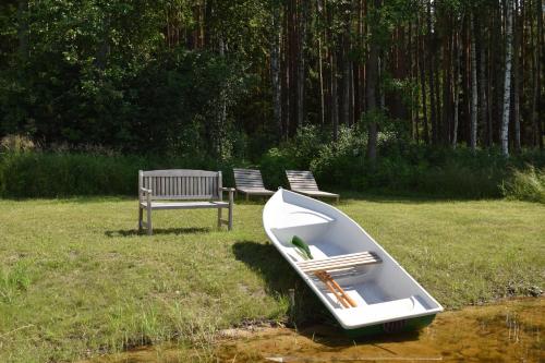a boat sitting on the grass next to a bench at Pirts "Spārītes" in Geraņimova