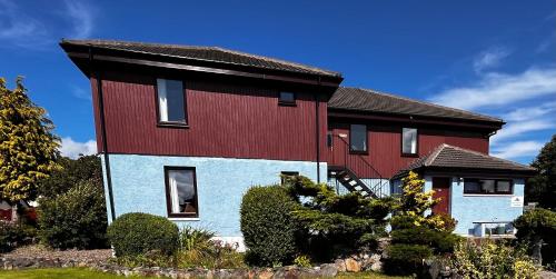 a house with a red and blue house at Snowgoose Apartments & Bunkhouse in Fort William