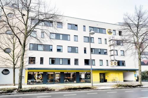un gran edificio blanco con fachada amarilla en B&B Hotel Bonn-West en Bonn