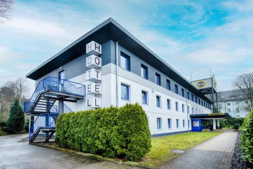 un bâtiment blanc avec un toit noir dans l'établissement B&B Hotel Bielefeld-Ost, à Bielefeld