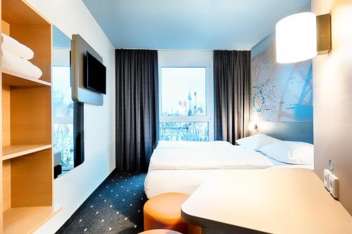 ボーフムにあるB&B Hotel Bochum-Cityのベッド2台とテレビが備わるホテルルームです。