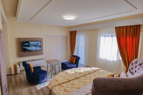 a bedroom with a bed and a table and chairs at Hotel Number One in Gjirokastër