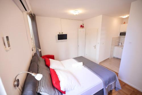 扎達爾的住宿－Sea Organ Apartment 2 (Oldtown Studio)，小卧室配有红色和白色枕头