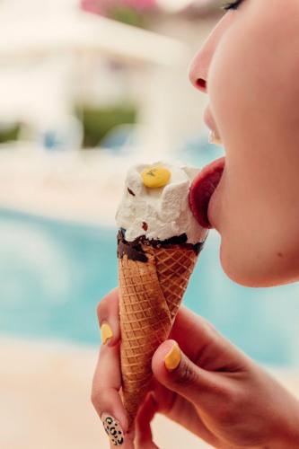 a woman is eating an ice cream cone at Hotel d'Or in Cala d´Or
