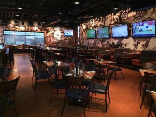 a restaurant with tables and chairs and televisions on the wall at Hawthorn Suites by Wyndham Erie in Erie