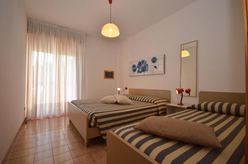 ビビオーネにあるAppartamenti Eridanoのベッドルーム1室(ベッド2台、窓付)