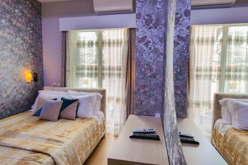 a bedroom with two beds and a purple wall at Hotel Number One in Gjirokastër