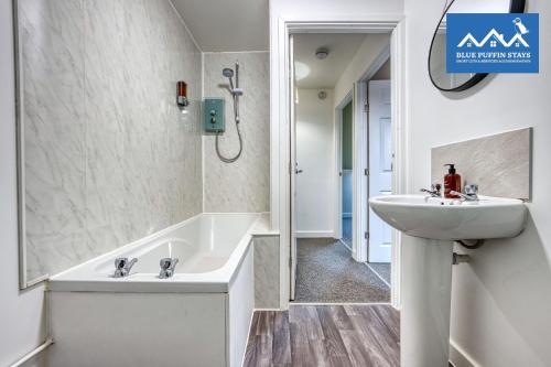 a bathroom with a sink and a bath tub at 4 Bed Design House, 2 Off-road Parking Spaces, Great for Groups - Central Gloucester By Blue Puffin Stays in Gloucester