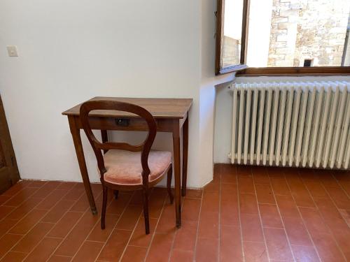 a wooden table with a chair next to a radiator at Torre Cavina in Palazzuolo sul Senio