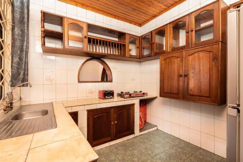 a kitchen with wooden cabinets and a sink at Dreamer's Holiday Home Arusha in Arusha