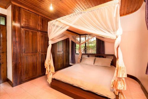 a bedroom with a bed with a canopy at Dreamer's Holiday Home Arusha in Arusha