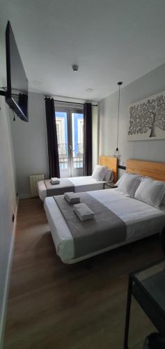 1 dormitorio con 2 camas y ventana grande en CH Lemon Rooms - Madrid en Madrid