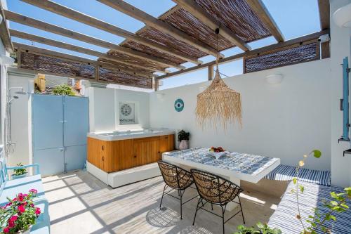 a patio with a table and chairs and a kitchen at Antigone Traditional House in Koskinou