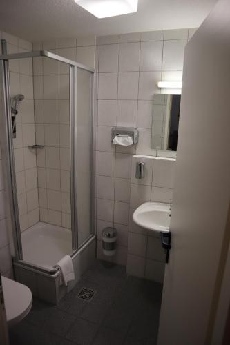 a bathroom with a shower and a toilet and a sink at Avenue Hotel in Nürnberg