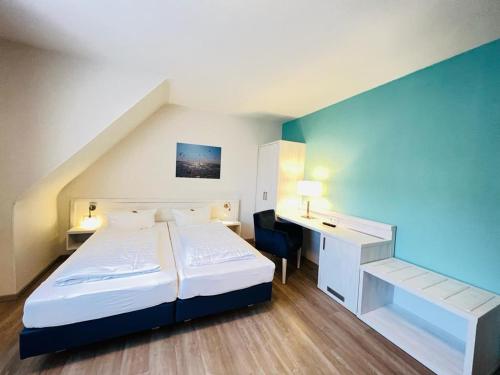 um quarto de hotel com uma cama e uma secretária e uma cama e um quarto em Haus zur Heimat em Cuxhaven