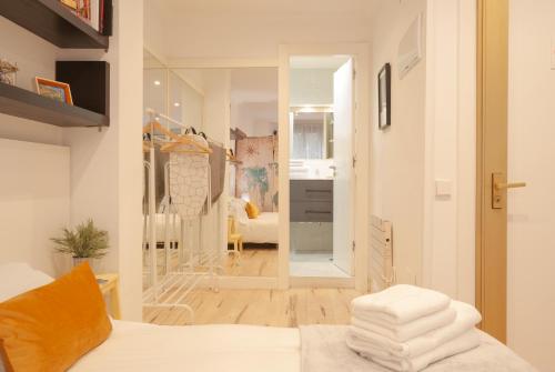 ヒホンにあるEl Rincón de Capuaの白いシーツと鏡付きのベッドが備わる客室です。