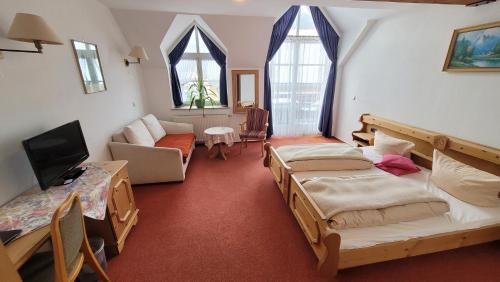 Habitación con 3 camas, sofá y TV. en Schwarzes Lamm, en Rothenburg ob der Tauber