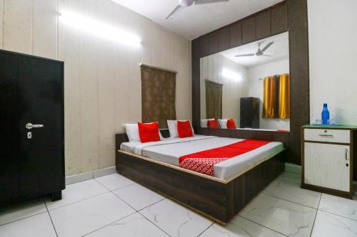 a bedroom with a bed with red pillows at OYO Hotel Sky Garden in Ludhiana