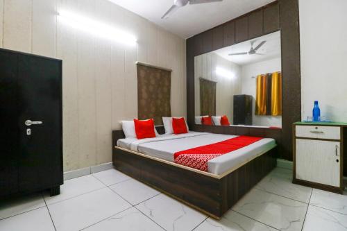 a bedroom with a bed with red pillows at Hotel O Sky Garden in Ludhiana